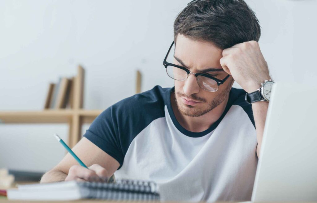 man reading cippe study guide and taking notes with pencil