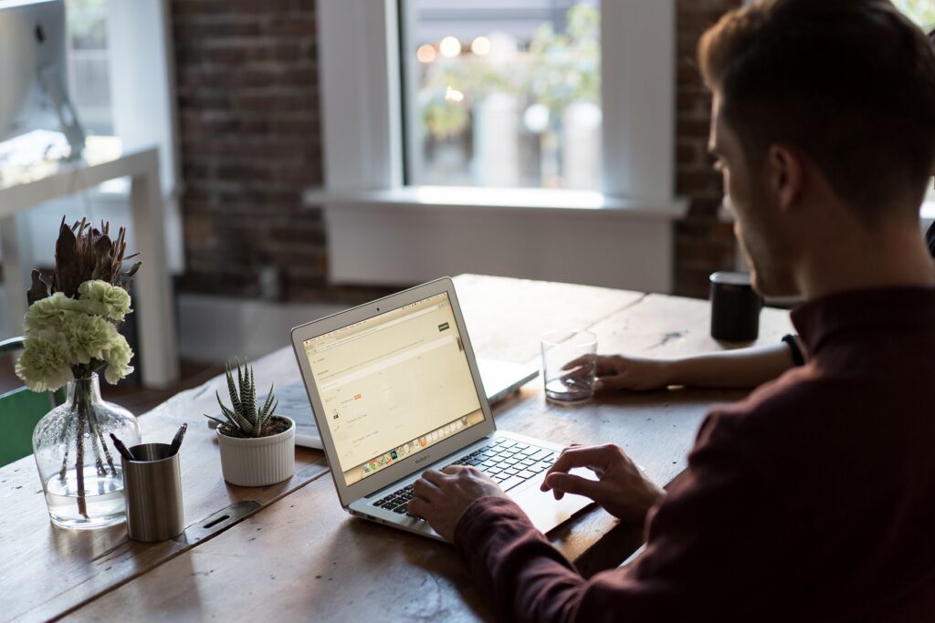 Person using a laptop at a desk with plants, preparing for an IAPP certification exam.