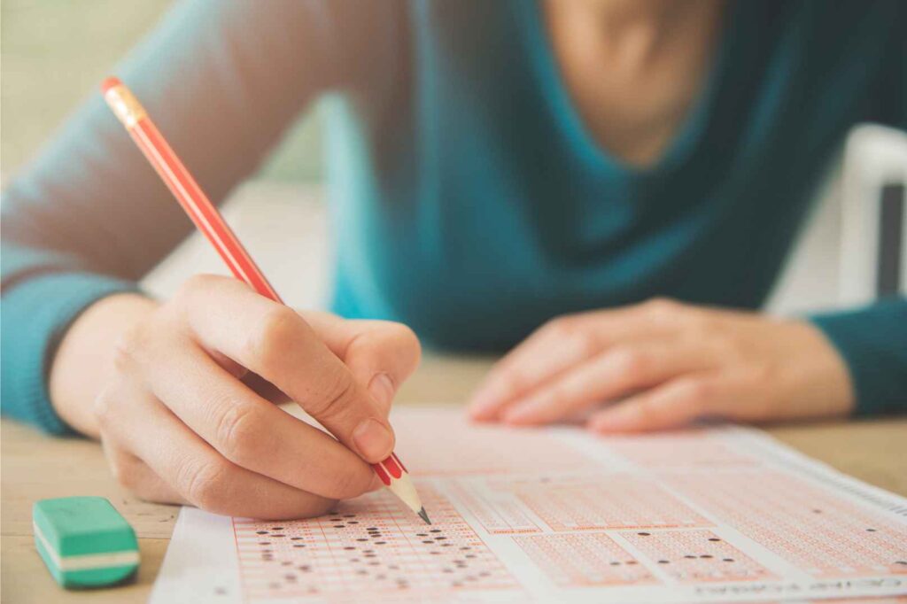 student taking a test on paper with a pencil