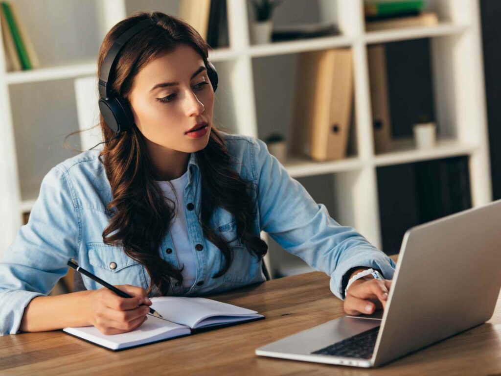 women with headphones, notebook and laptop attending online privacy training